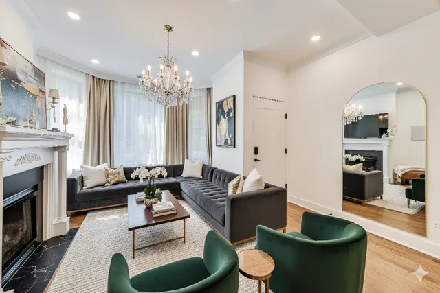 a living room with furniture a fireplace and a chandelier