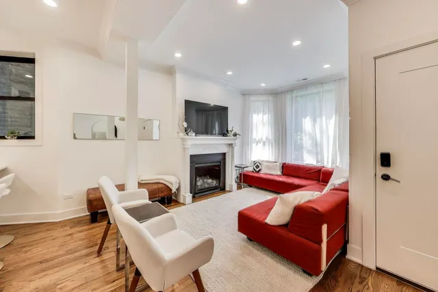 a living room with furniture and a dining table with wooden floor