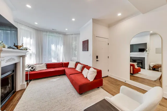 a living room with furniture a dining table and chairs with wooden floor