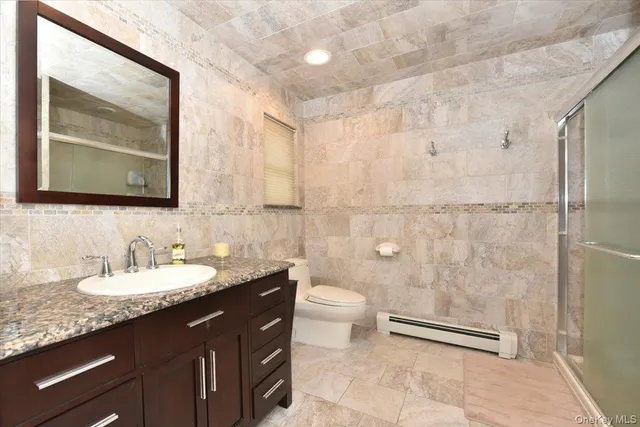 a bathroom with a granite countertop sink a toilet and a mirror
