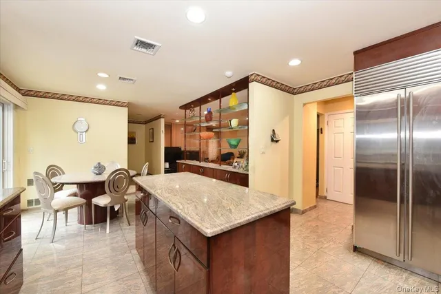 a kitchen with a refrigerator and table chair
