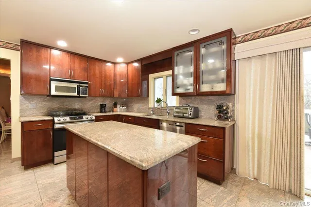 a kitchen with a stove a sink a microwave and island