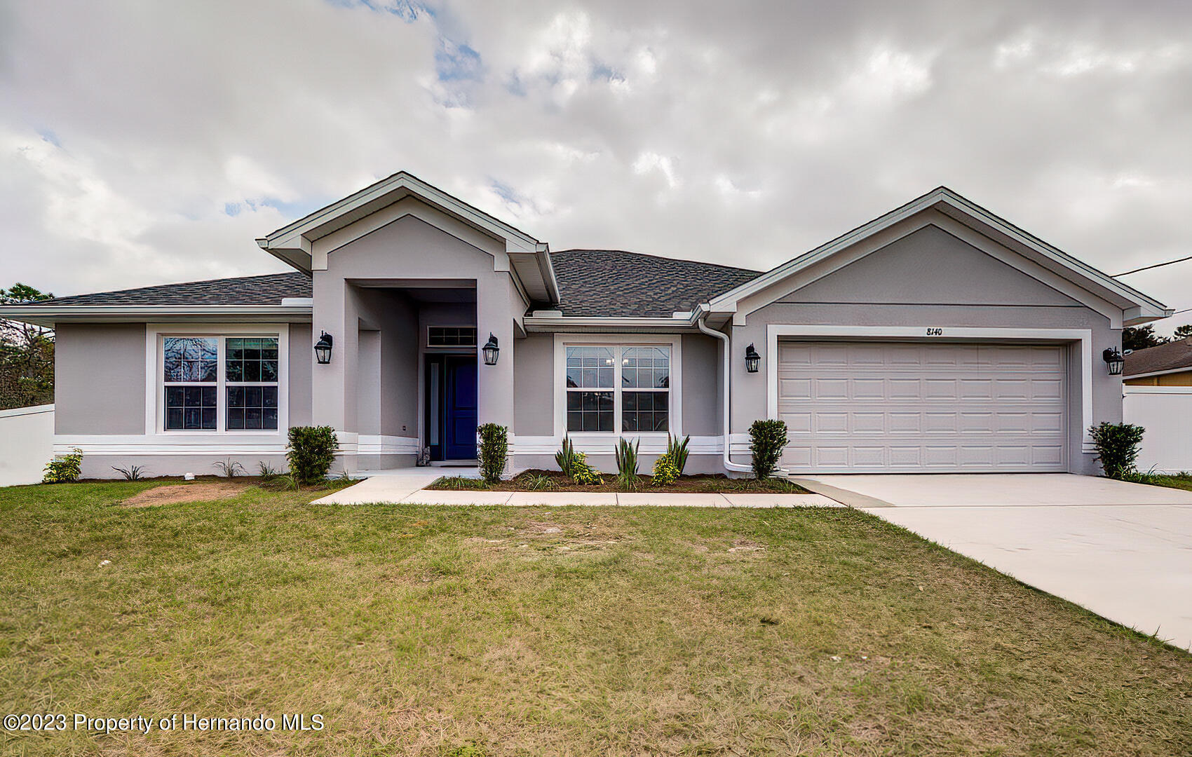 8140 Jasbow Junction Weeki Wachee, FL 34613 - Photo 1 of 37 a front view of a house with a yard and garage