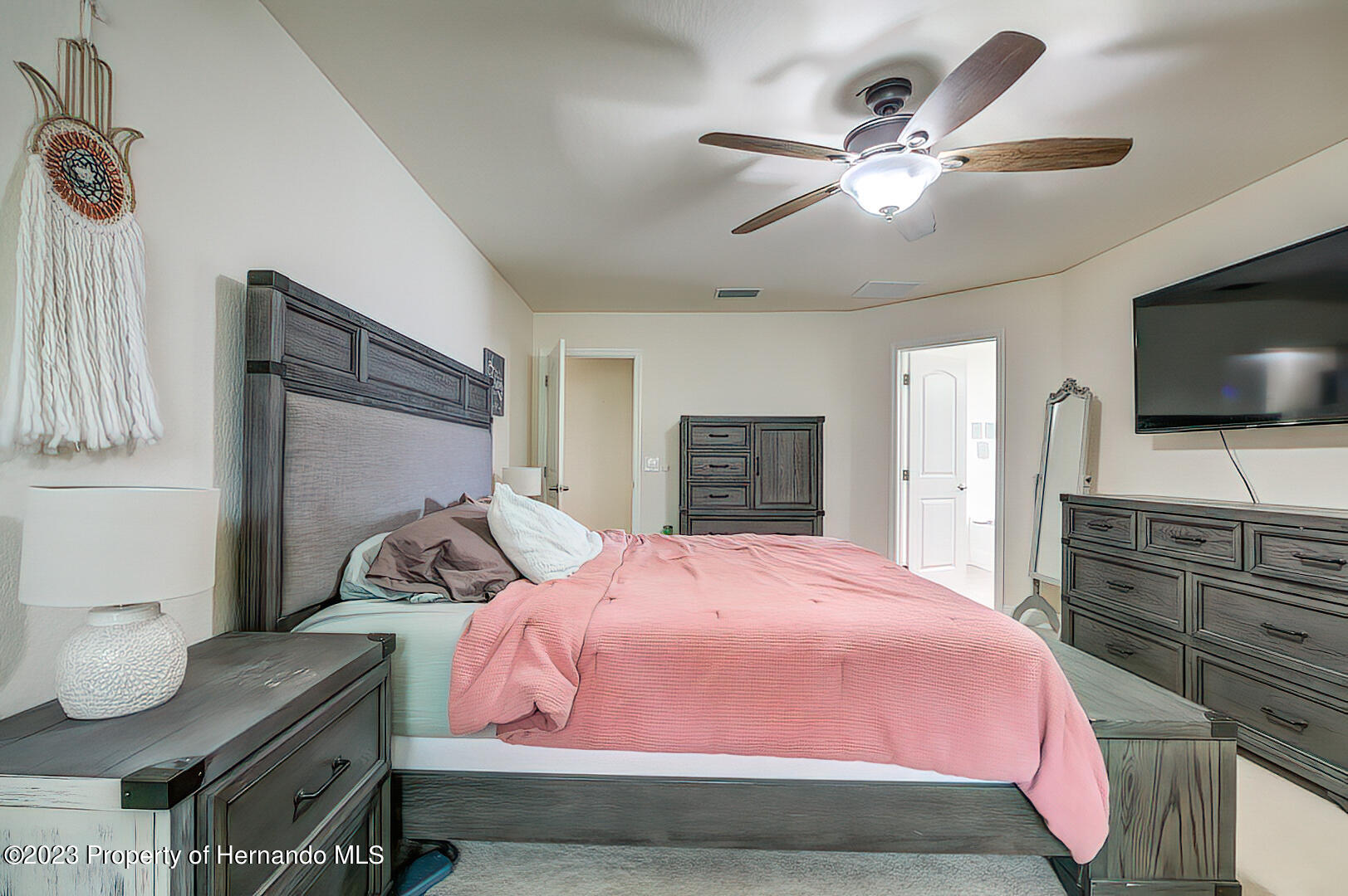 8140 Jasbow Junction Weeki Wachee, FL 34613 - Photo 24 of 37 a bedroom with a bed and a flat screen tv