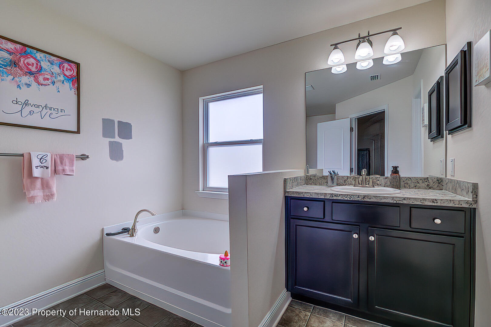 8140 Jasbow Junction Weeki Wachee, FL 34613 - Photo 25 of 37 a bathroom with a tub sink and mirror