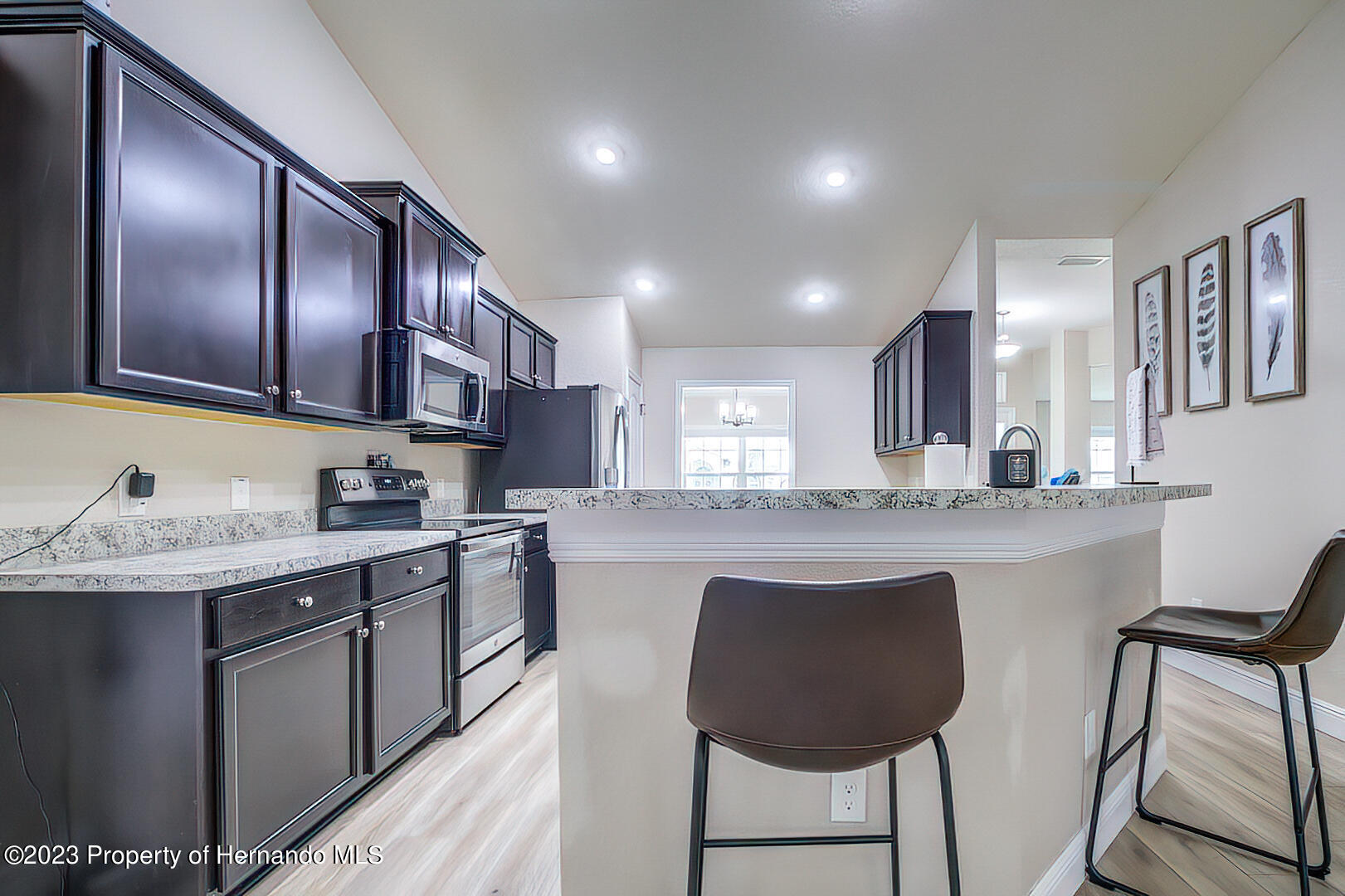 8140 Jasbow Junction Weeki Wachee, FL 34613 - Photo 8 of 37 a kitchen with stainless steel appliances granite countertop wooden cabinets a stove top oven a sink and dishwasher