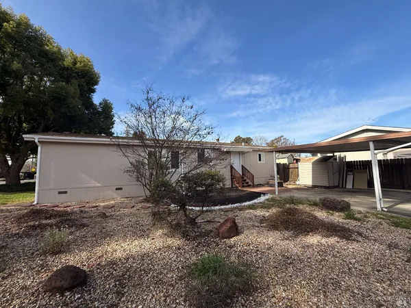 a view of a grey house with a yard
