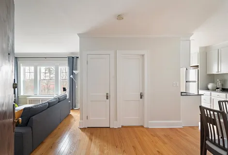 a spacious bedroom with a bed and wooden floor