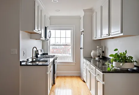 a kitchen with stainless steel appliances granite countertop a sink a counter space and a window