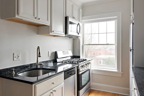 a kitchen with granite countertop a sink and a stove