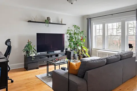 a living room with furniture a large window and a flat screen tv