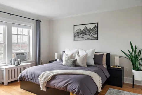 a bedroom with bed and a large window