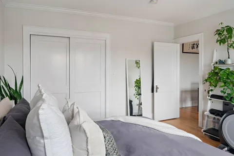 a bedroom with a bed and a potted plant