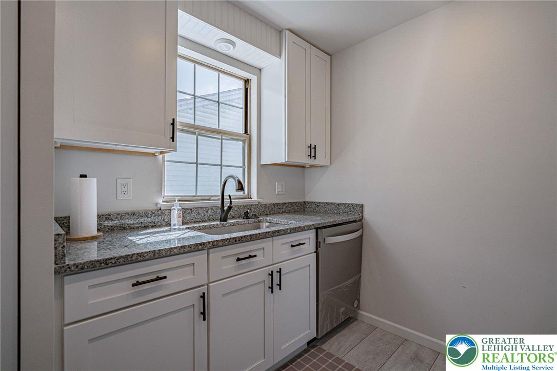 25 North 8th Street Emmaus, PA 18049 - Photo 12 of 51 A compact kitchen area with sleek cabinetry and durable granite countertops, perfect for efficient culinary tasks.