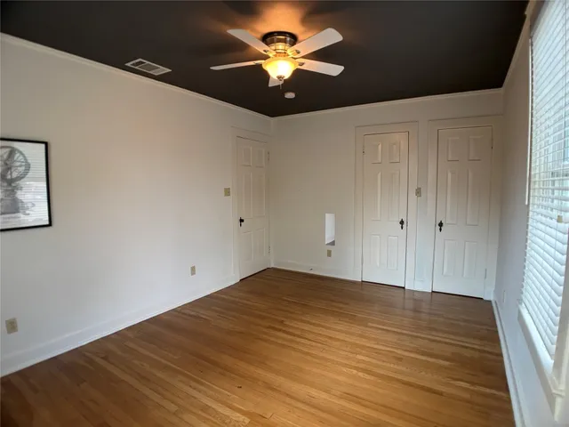 a view of room with a ceiling fan and wooden floor