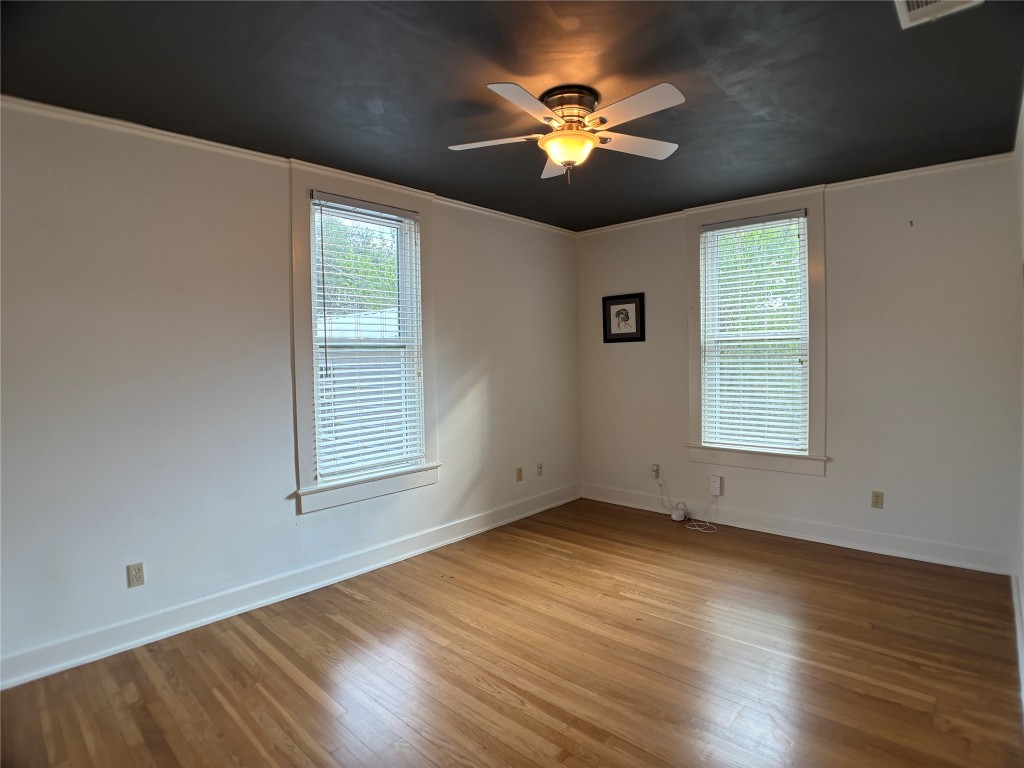 5808 Coventry Lane Austin, TX 78723 - Photo 13 of 27 a view of an empty room with a window and wooden floor