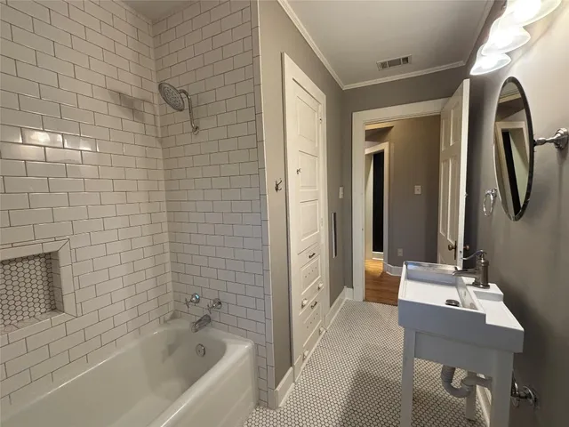 a bathroom with a bathtub shower sink and mirror