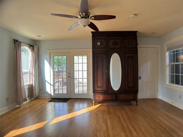 a view of a livingroom with wooden floor and a large window