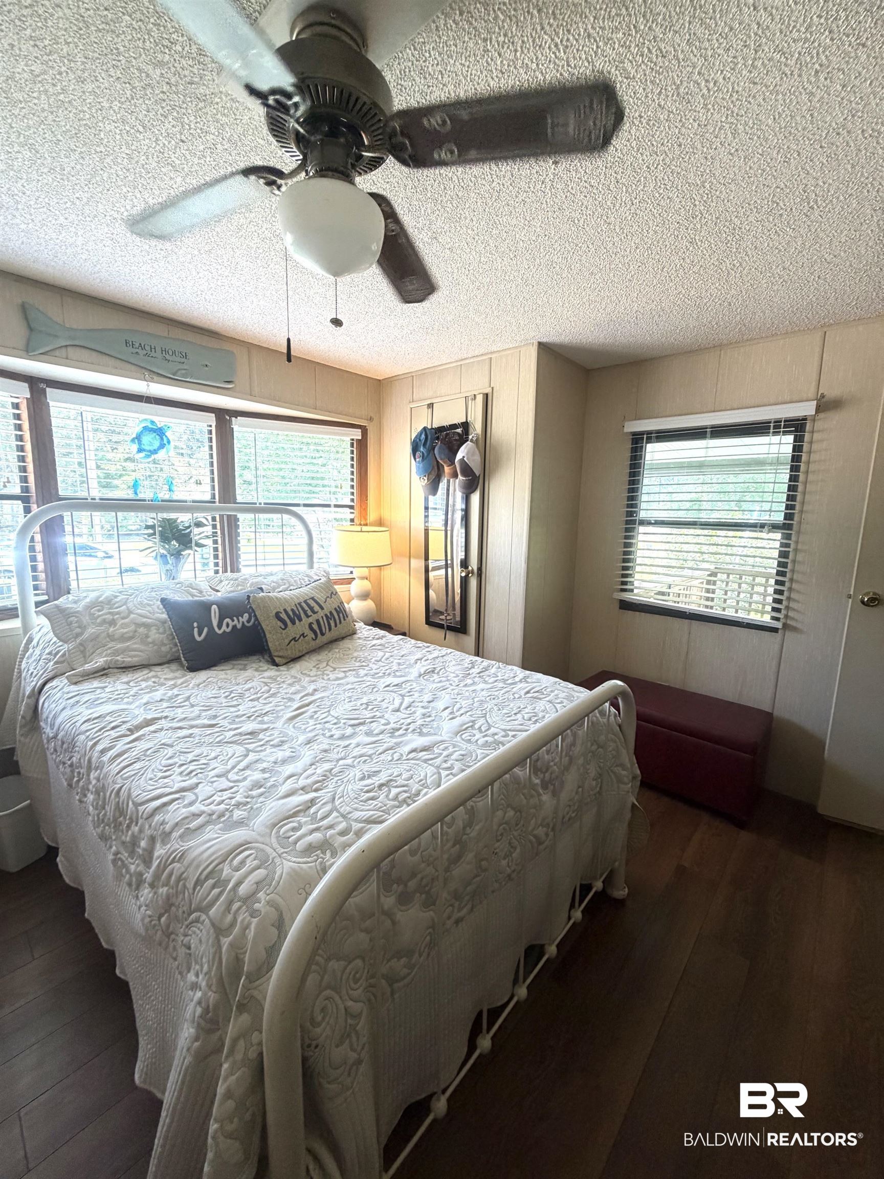 1620 Del Rey Drive Lillian, AL 36549 - Photo 18 of 45 Room featuring wood-finish flooring, paneled wall finishes, and multiple windows with blinds