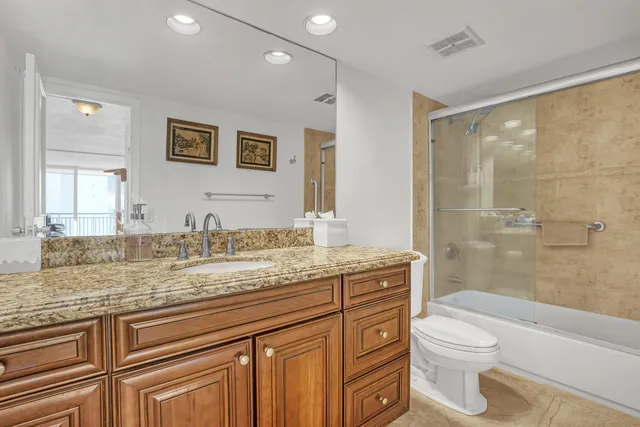 a kitchen with granite countertop a sink cabinets and stainless steel appliances