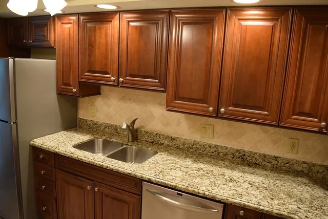 a kitchen with cabinets stainless steel appliances and wooden floor