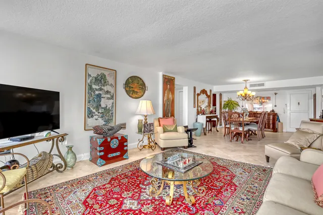 a living room with furniture a flat screen tv and a floor to ceiling window