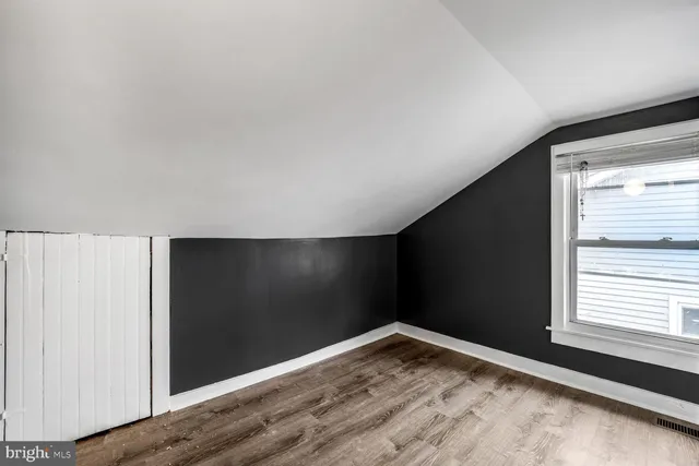 a view of empty room with wooden floor
