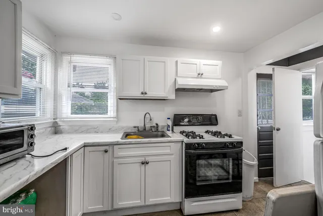 a kitchen with stainless steel appliances a stove a sink and cabinets