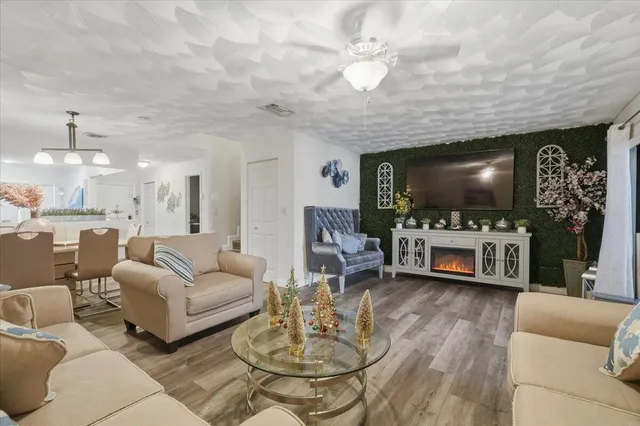 a living room with furniture a flat screen tv and kitchen view