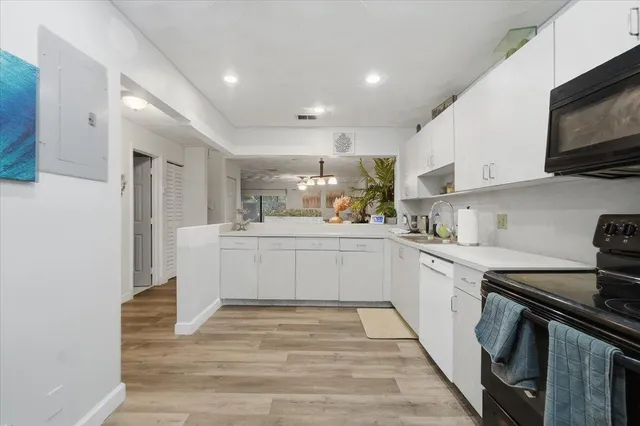 a kitchen with a sink stainless steel appliances and white cabinets