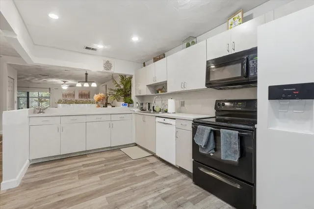 a kitchen with stainless steel appliances granite countertop a stove a sink and a microwave