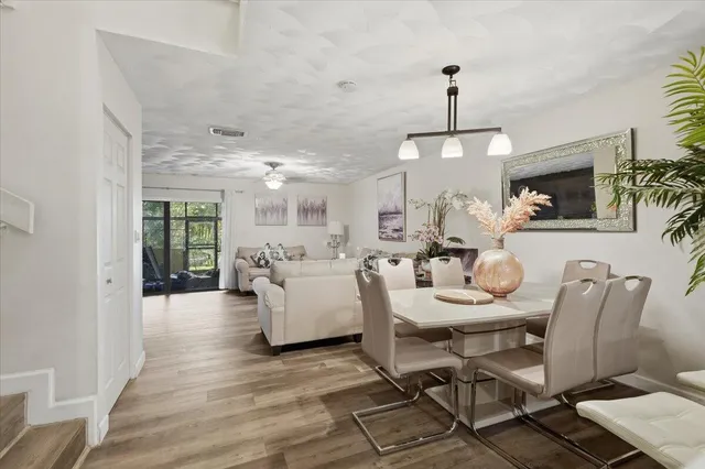 a dining room with furniture a chandelier and wooden floor