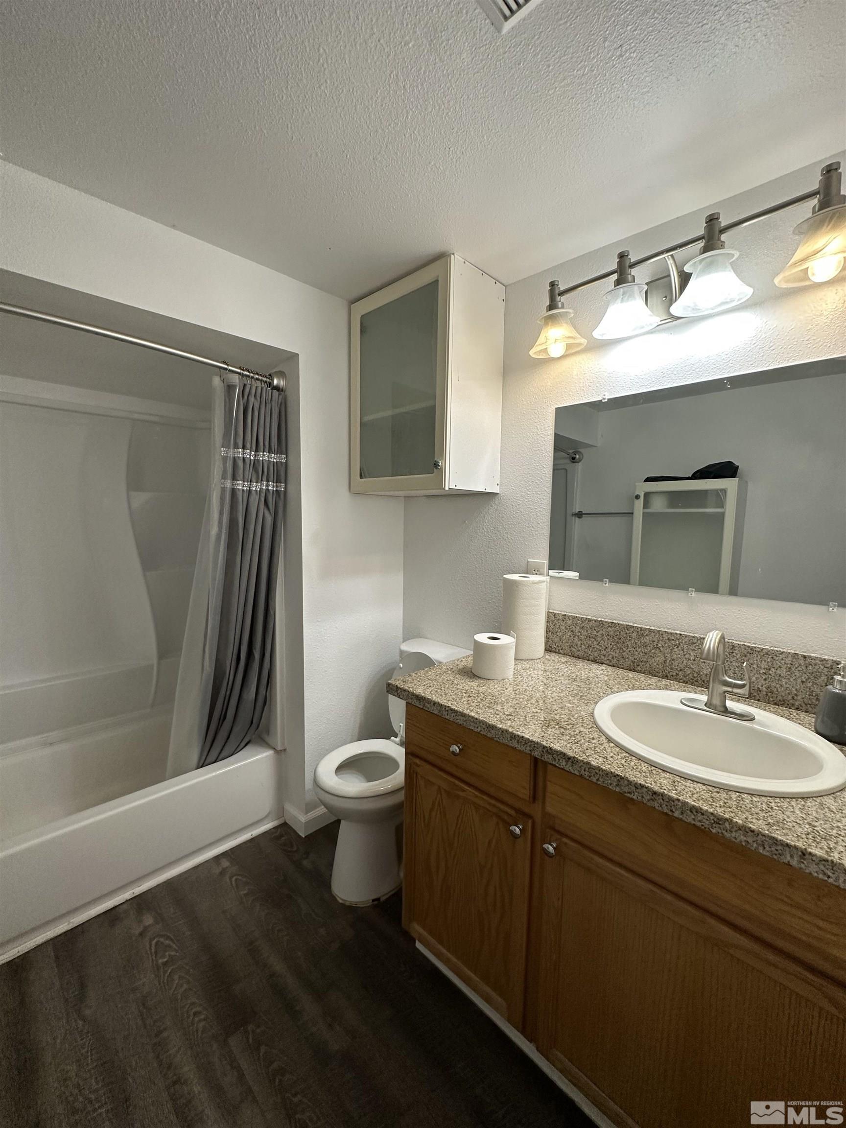 15119 Kivett Lane Reno, NV 89521 - Photo 11 of 20 a bathroom with a granite countertop sink toilet and shower