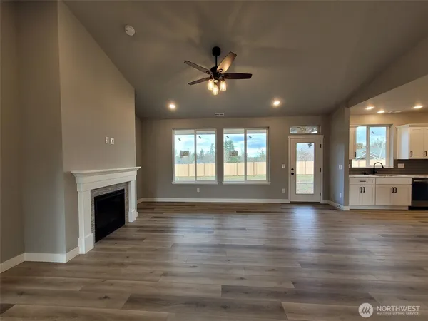 a view of an empty room with a fireplace and a window