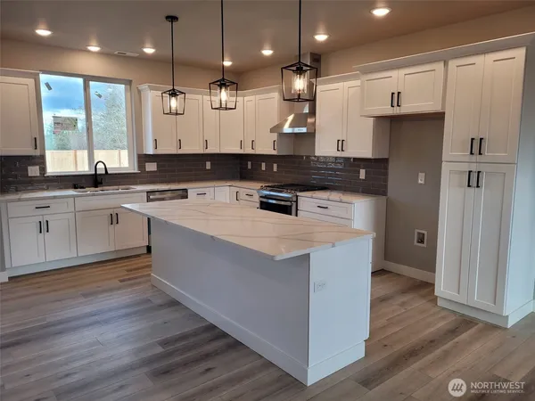 an open kitchen with a sink and wooden cabinets