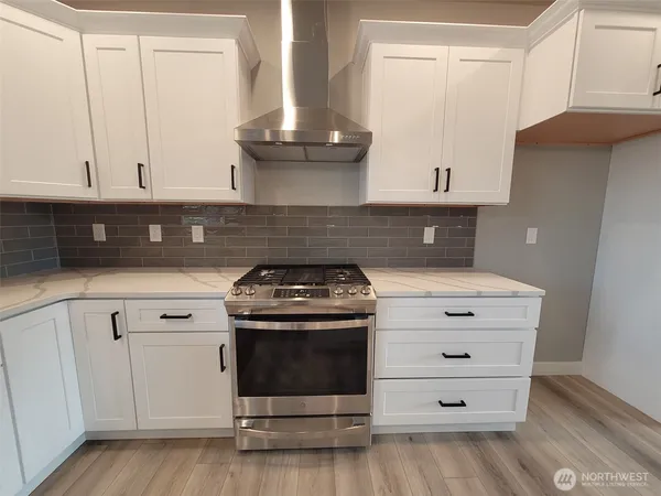 a white stove top oven sitting inside of a kitchen
