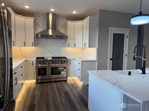 a kitchen with stainless steel appliances a stove a sink a refrigerator and a oven