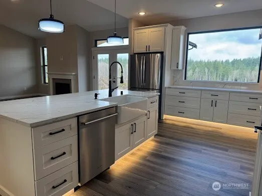 a kitchen with stainless steel appliances a sink cabinets and wooden floor