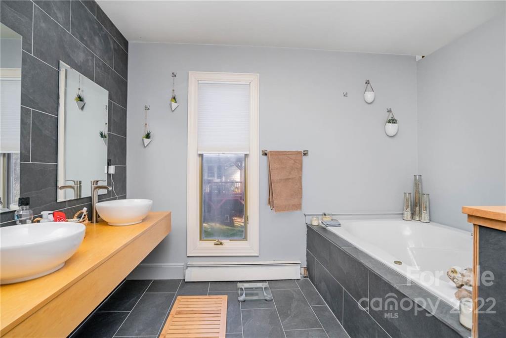 660 6th Street Northwest Hickory, NC 28601 - Photo 19 of 39 a bathroom with a granite countertop tub sink and mirror