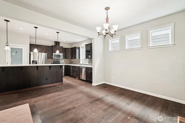 a large kitchen with a stove a refrigerator and a fireplace with wooden floor