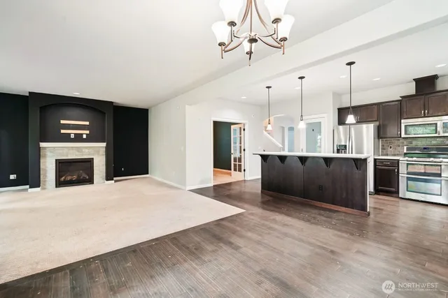 a kitchen with a stove a sink a microwave oven and a dining table with wooden floor