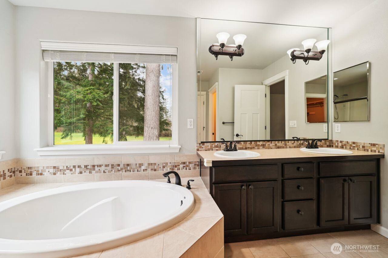 4335 Dudley Drive Northeast Lacey, WA 98516 - Photo 35 of 39 a bathroom with a tub a sink and a large mirror