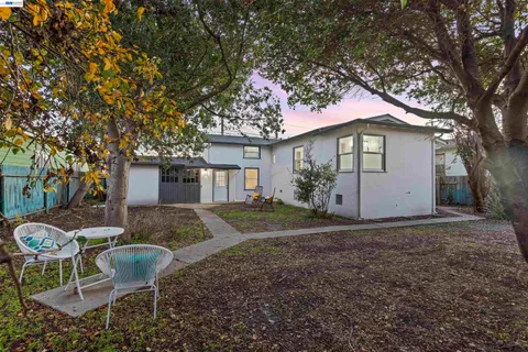 a view of a house with backyard and a tree