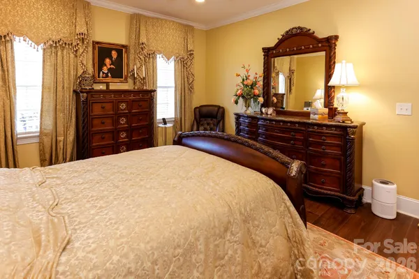 a spacious bedroom with a bed and wooden floor