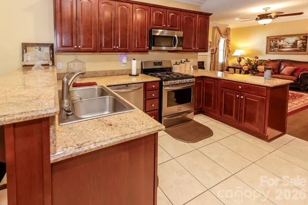a kitchen with stainless steel appliances granite countertop a stove a sink a microwave and refrigerator