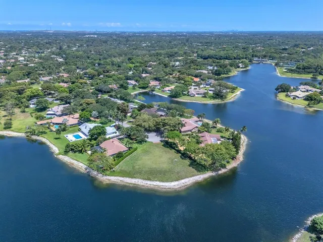an aerial view of residential houses with outdoor space and trees