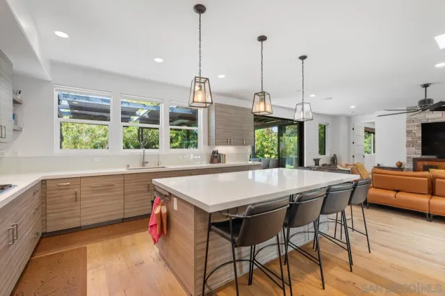 a kitchen with stainless steel appliances granite countertop a kitchen island a stove and a sink
