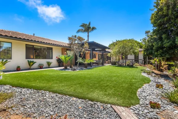 a view of a house with a yard and a tree