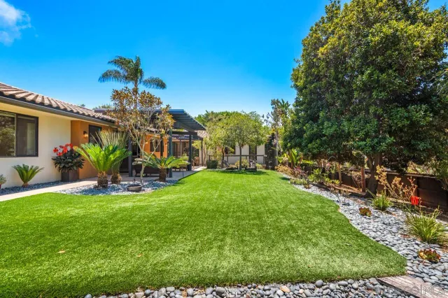 a view of a house with backyard sitting area and garden