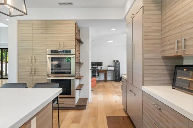 a kitchen with stainless steel appliances kitchen island granite countertop a stove a sink and a refrigerator